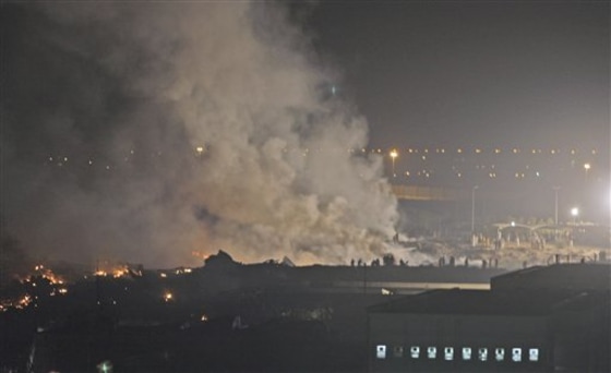 Smoke rises from the site of a cargo plane that crashed Sept. 3 in Dubai, United Arab Emirates. Safety advocates have warned for more than a decade that someday an air shipment of lithium batteries like those used in countless cameras, cell phones and other products would catch fire, causing a plane to crash and people to die.